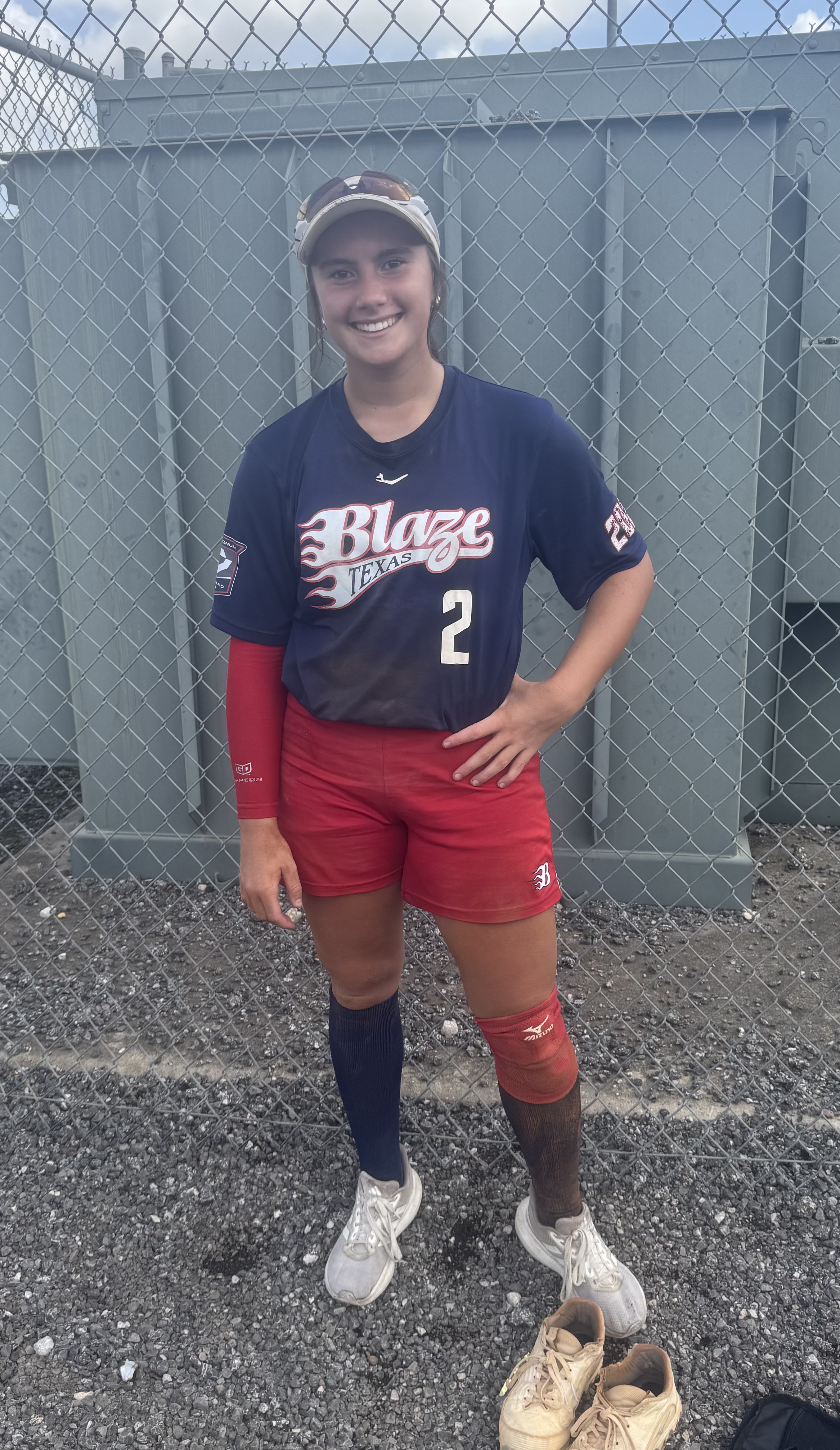 Kaylee Covanes in her Blaze Texas uniform smiling at the field after a game