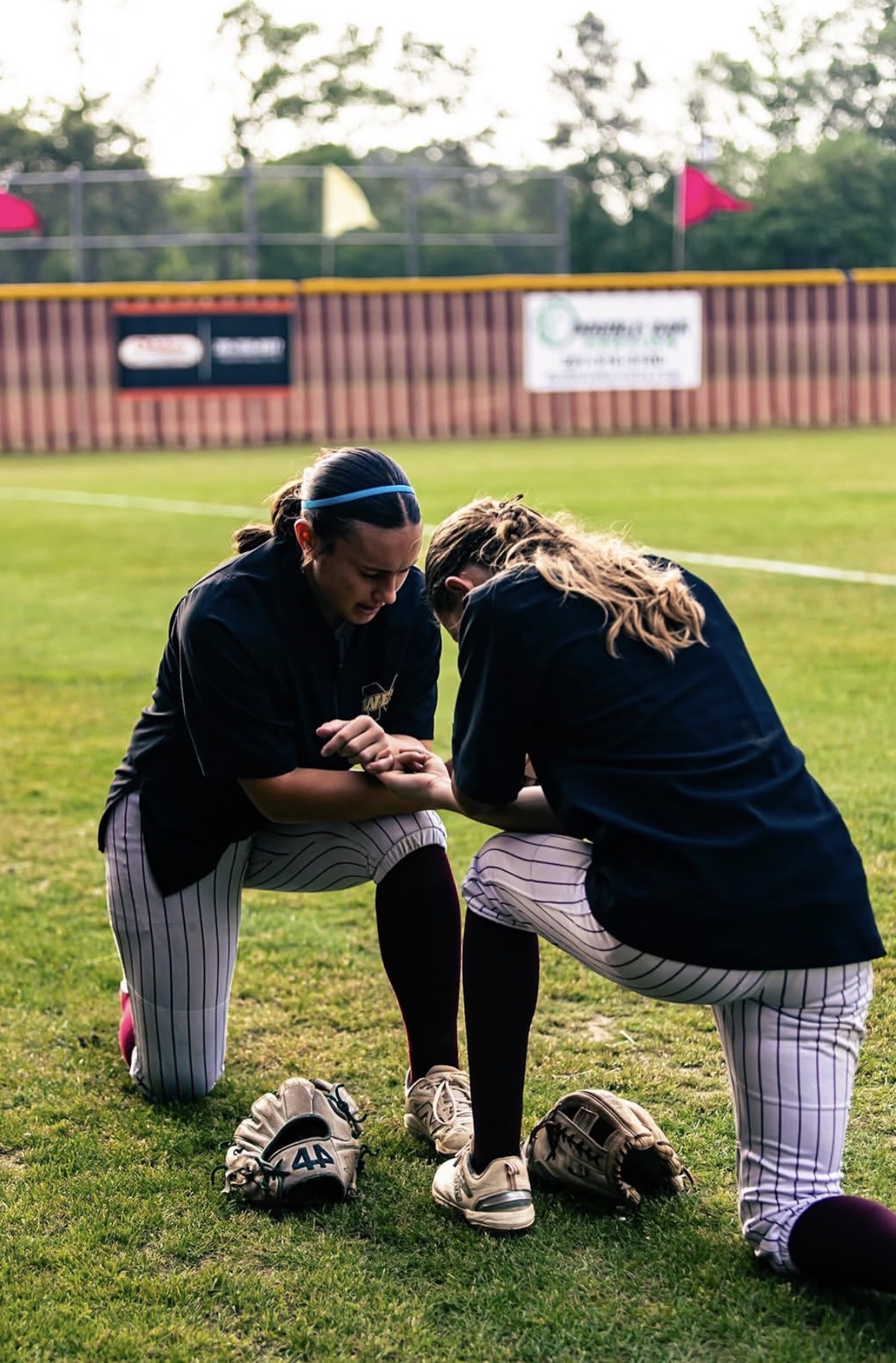 Kaylee Covanes and a teammate on the field before a game