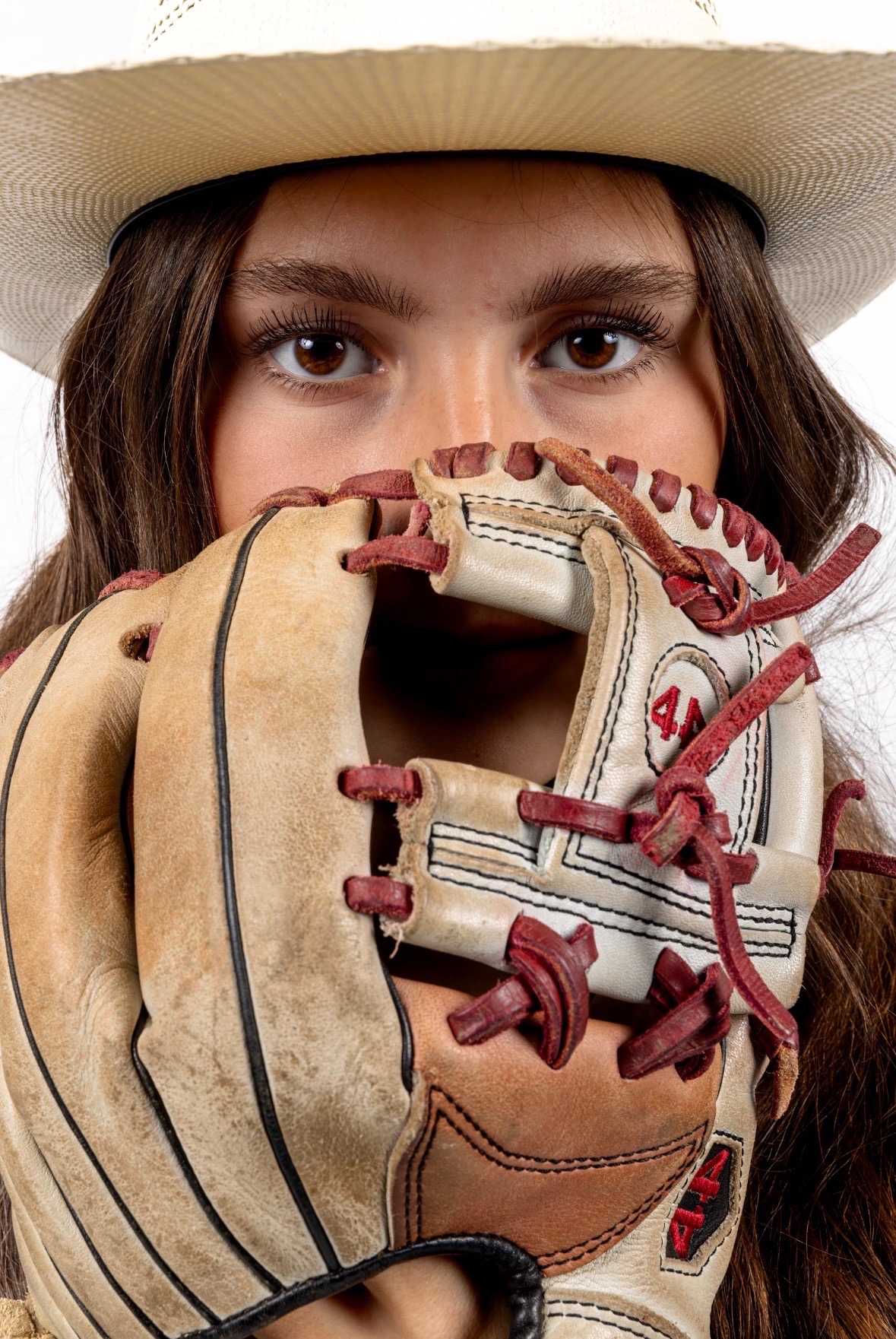 Close-up of Kaylee Covanes' eyes through the webbing of her catcher's mitt